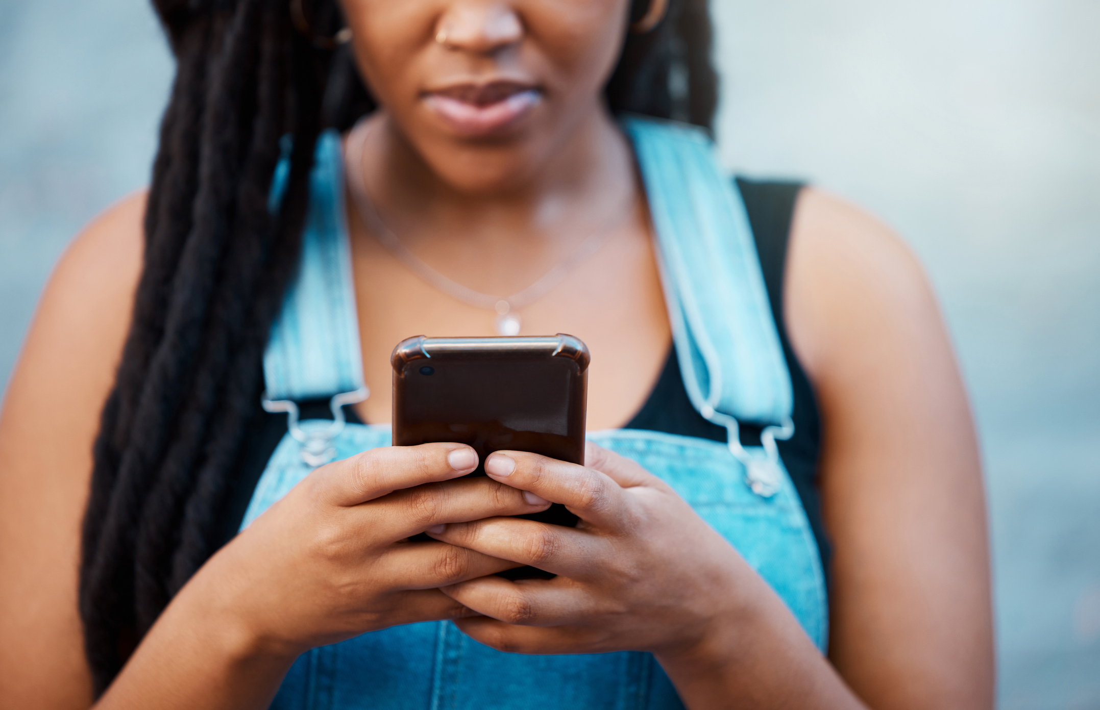 Black woman hands with smartphone for social media, website contact information or reading online blog newsletter in youth urban lifestyle. Teenager with cellphone typing on chat app or 5g networking