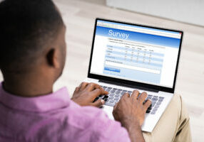 Man Giving Online Survey On Laptop